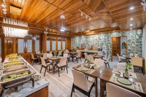 a restaurant with wooden ceilings and tables and chairs at Mixay Boutique Hotel Da Nang in Da Nang