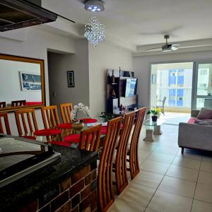 a living room with a dining table and chairs at Requinte e sofisticação in Praia Grande