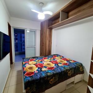a bedroom with a bed with a colorful blanket at Requinte e sofisticação in Praia Grande +46 photos