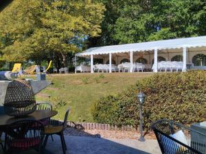 a pavilion with tables and chairs in a park at Détente au Moulin: Piscine, Jacuzzi, Animaux Bienvenus - FR-1-591-641 in Rouvres-les-Bois