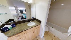 a bathroom with a sink and a toilet and a mirror at Spacious Waikiki Banyan Condo with Ample Sleeping, Walk to Beach, Great Views and Free Parking (22201) in Honolulu +18 photos
