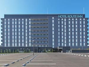 栗东Hotel Route Inn Kusatsu Ritto -Ritto Inter Kokudo 1 gou-的一栋酒店大楼前有一个停车场
