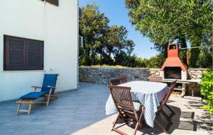 a patio with a table and chairs and a fireplace at Stunning Apartment In Sucuraj With Wifi in Sućuraj
