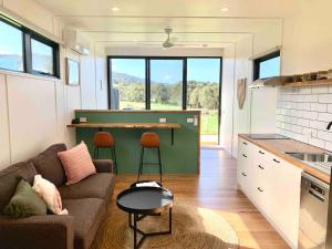 a kitchen and living room with a couch and a table at Farm Stay - Apollo Bay Tiny Stays in Apollo Bay