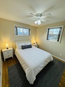 a bedroom with a white bed with a ceiling fan at North Bethesda Gem - Entire House 5 min from Metro in Rockville