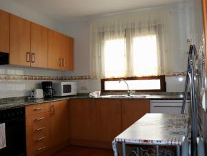 a kitchen with wooden cabinets and a sink and a window at Casa Rural Claudia in Albarracín +26 photos