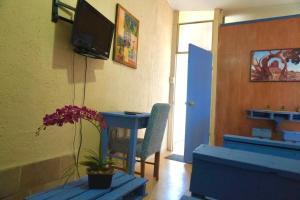 a room with a table and a chair and a television at A mini apartment in Cuernavaca, in a good location in Cuernavaca