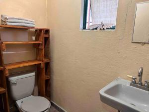 a bathroom with a white toilet and a sink at A mini apartment in Cuernavaca, in a good location in Cuernavaca +9 photos