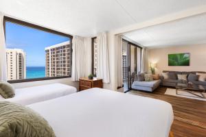 a hotel room with two beds and a large window at Sky-High Oceanview Escape at Waikiki Banyan with Free Parking (23214) in Honolulu