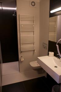 bagno con lavandino, servizi igienici e specchio di Hotel Jakuszyce Sport & Spa a Szklarska Poręba
