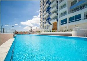 a large swimming pool in front of a building at Oceanica Departamento in Iquique