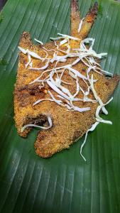 a piece of food on a green leaf at Coco Palm Eco Resort in Achra