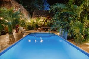 a blue swimming pool in a yard with palm trees at Kasakolà in Palomino