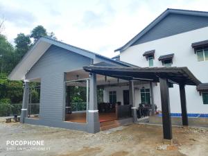 une maison avec un toit en métal dans l'établissement Villa Gong Badak, Kuala Terengganu, à Kuala Terengganu