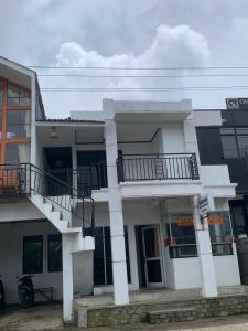 a white building with a balcony on top of it at Homestay Talago minang dieng in Dieng