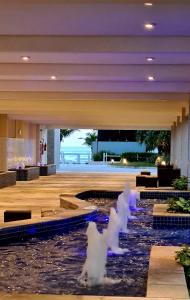 a lobby with a water fountain in the middle at Requinte e sofisticação in Praia Grande