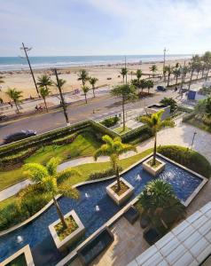 an aerial view of a park with palm trees and a beach at Requinte e sofisticação in Praia Grande