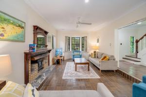 Una sala de estar con un sofá y una chimenea. en Lake House, en Kawana Waters