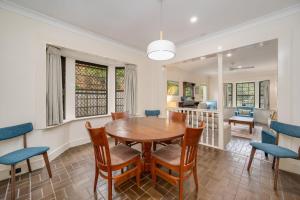 Un comedor con mesa y sillas de madera. en Lake House, en Kawana Waters