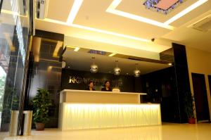 two people sitting at a counter in a lobby at KK Waterfront Hotel in Kota Kinabalu