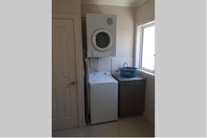 a small kitchen with a refrigerator and a microwave at Lbarza Prime CBD 2BR Townhouse near lake and restaurants in Shepparton