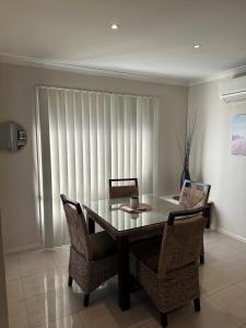 a dining room with a glass table and chairs at Lbarza Prime CBD 2BR Townhouse near lake and restaurants in Shepparton