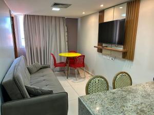 Una sala de estar con un sofá y una mesa con sillas. en Bela Hospedagem - Imperial Flat - Beira mar de Tambaú, en João Pessoa