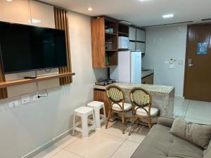 sala de estar con bar con sillas y TV en Bela Hospedagem - Imperial Flat - Beira mar de Tambaú, en João Pessoa