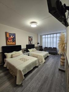 a bedroom with two beds and a flat screen tv at ESPACIOSA y MODERNA SUITE in Bogotá