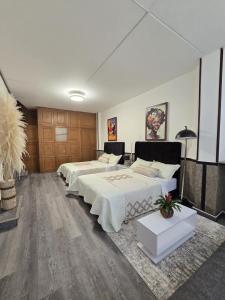 two beds in a large room with wooden cabinets at ESPACIOSA y MODERNA SUITE in Bogotá