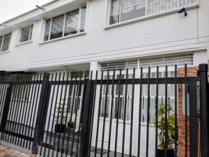 a black fence in front of a white house at ESPACIOSA y MODERNA SUITE in Bogotá +5 photos