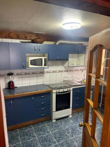 Una cocina con gabinetes azules y un microondas. en Casa Rukalma Centro, en Villarrica