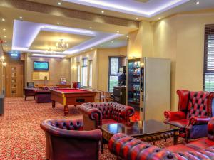 a living room filled with furniture and a tv at Grainger Hotel in Newcastle upon Tyne