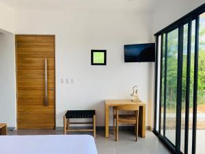a bedroom with a bed and a desk and a door at Villa Francia in San Juan del Sur