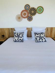 a bed with pillows and decorations on the wall at Villa Francia in San Juan del Sur