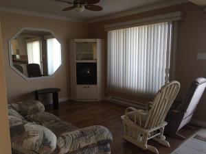 a living room with a couch and a chair and a mirror at Beautiful cottage on Lake Abitibi in Palmarolle