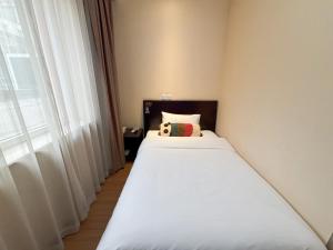 a bedroom with two beds and a window at 北京金泰之家宾馆有限公司西直门店 in Beijing