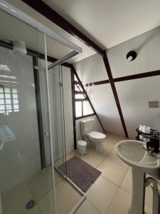 a bathroom with a glass shower and a toilet at Chalé em Ubatuba para 12 pessoas com Wi-Fi in Ubatuba +13 photos