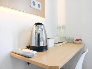 a kitchen counter with a coffee maker on it at Urbanview Hotel Manggala Maguwoharjo in Kalasan