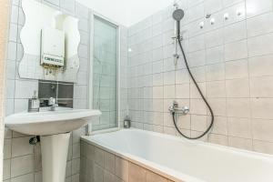ウィーンにあるStylish 2BR shared Apt, Central with Easy City Accessの洗面台とバスタブを備えた白いバスルーム