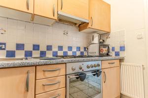 ウィーンにあるStylish 2BR shared Apt, Central with Easy City Accessの木製のキャビネットとコンロ付きオーブンを備えたキッチン +19枚の写真