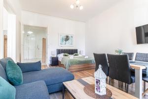 ウィーンにあるStylish 2BR shared Apt, Central with Easy City Accessの青いソファとベッドのあるリビングルーム