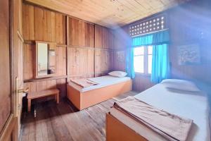 a small room with two beds and a window at Villa Paul Pamijahan RedPartner in Gunungpicung