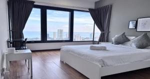 Schlafzimmer mit einem weißen Bett und großen Fenstern in der Unterkunft 218 Macalister Food Paradise By Smart Space Home in George Town