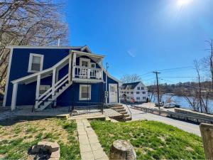 une maison bleue avec un balcon sur le côté. dans l'établissement NEW - Mins to Manchester - Concord - River Views, à Hooksett