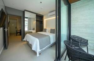 - une chambre avec un lit et un balcon avec deux chaises dans l'établissement Apartamento de Luxo no Resort GAV, Muro Alto, Porto de Galinhas, à Ipojuca 27 autres photos