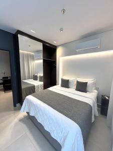 une chambre d'hôtel avec deux lits et un miroir dans l'établissement Apartamento de Luxo no Resort GAV, Muro Alto, Porto de Galinhas, à Ipojuca