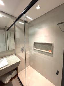 une salle de bain avec une douche en verre et un lavabo dans l'établissement Apartamento de Luxo no Resort GAV, Muro Alto, Porto de Galinhas, à Ipojuca