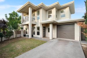 a large house with a garage at Fig & Fern - Modern Comfort between City & Coast in Glandore