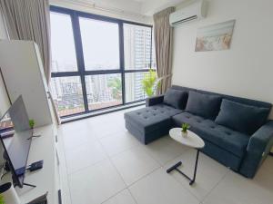 Infinity Pool, Urban Suites, Georgetown, 2 Car Parks by Star Home في جورج تاون: غرفة معيشة مع أريكة زرقاء ونوافذ كبيرة